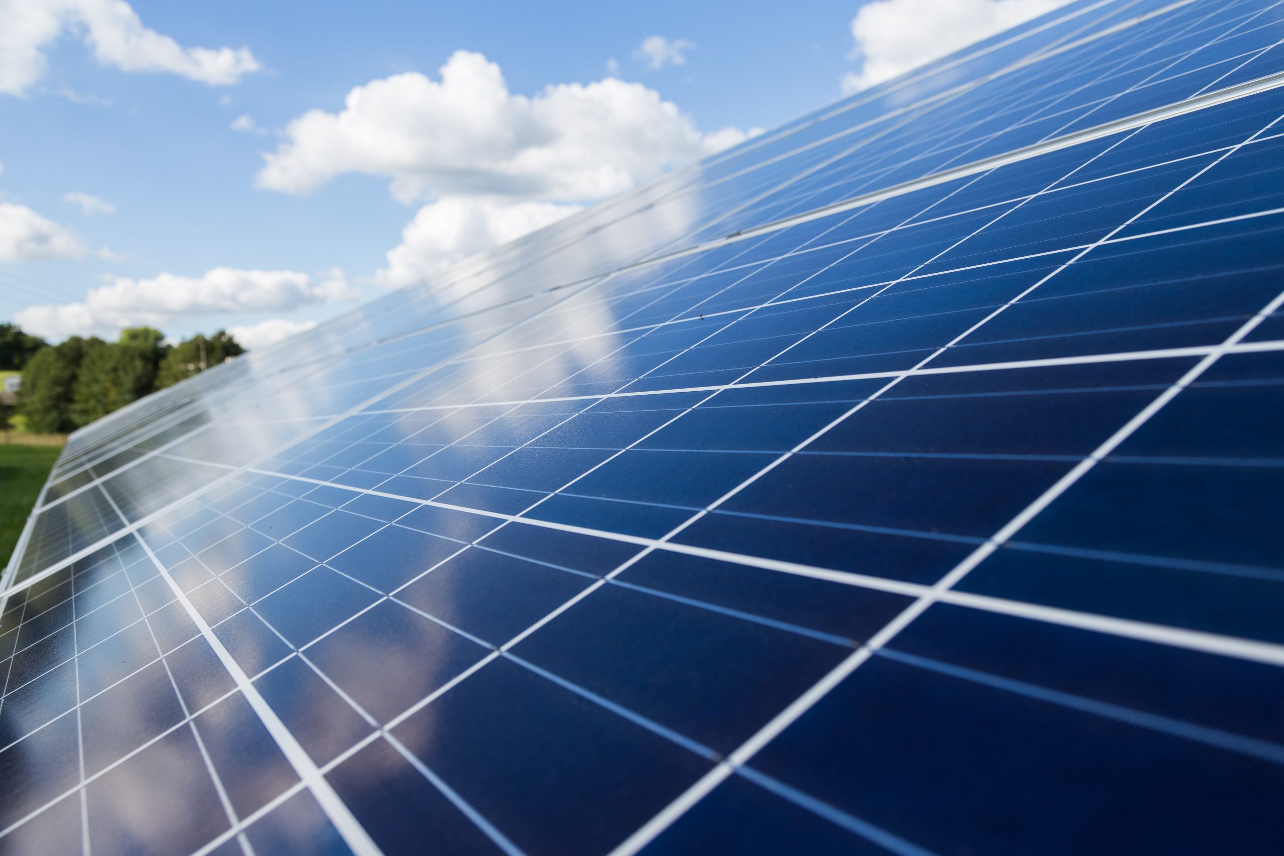 Modules photovoltaïques sous un ciel bleu avec quelques nuages